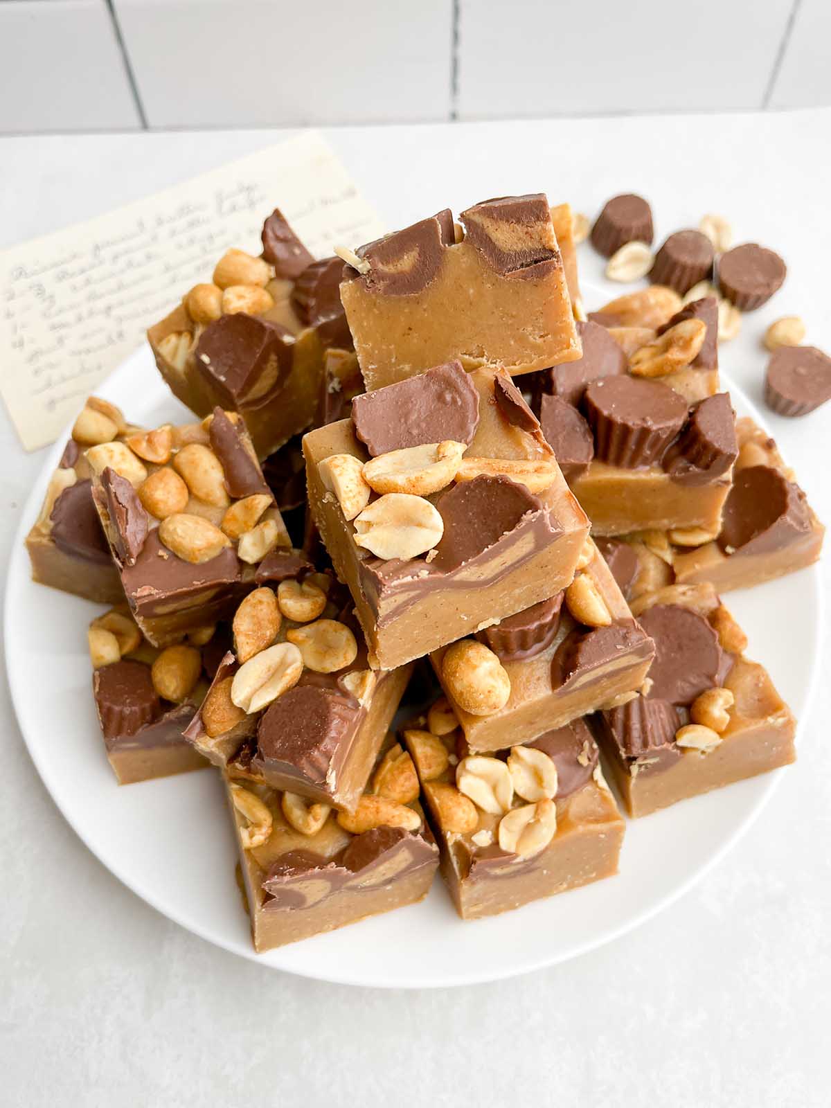 Squares of no bake peanut butter fudge on a white plate. 