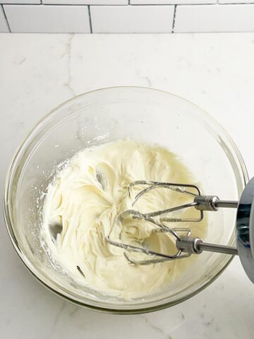 cream cheese frosting in a clear bowl.