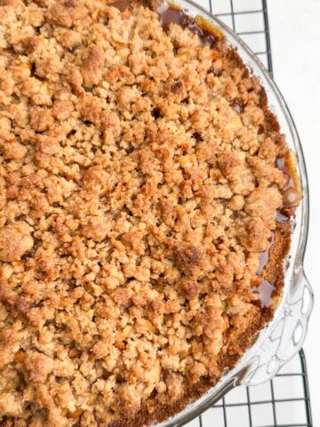 close up of half of baked apple pie with graham cracker crust.