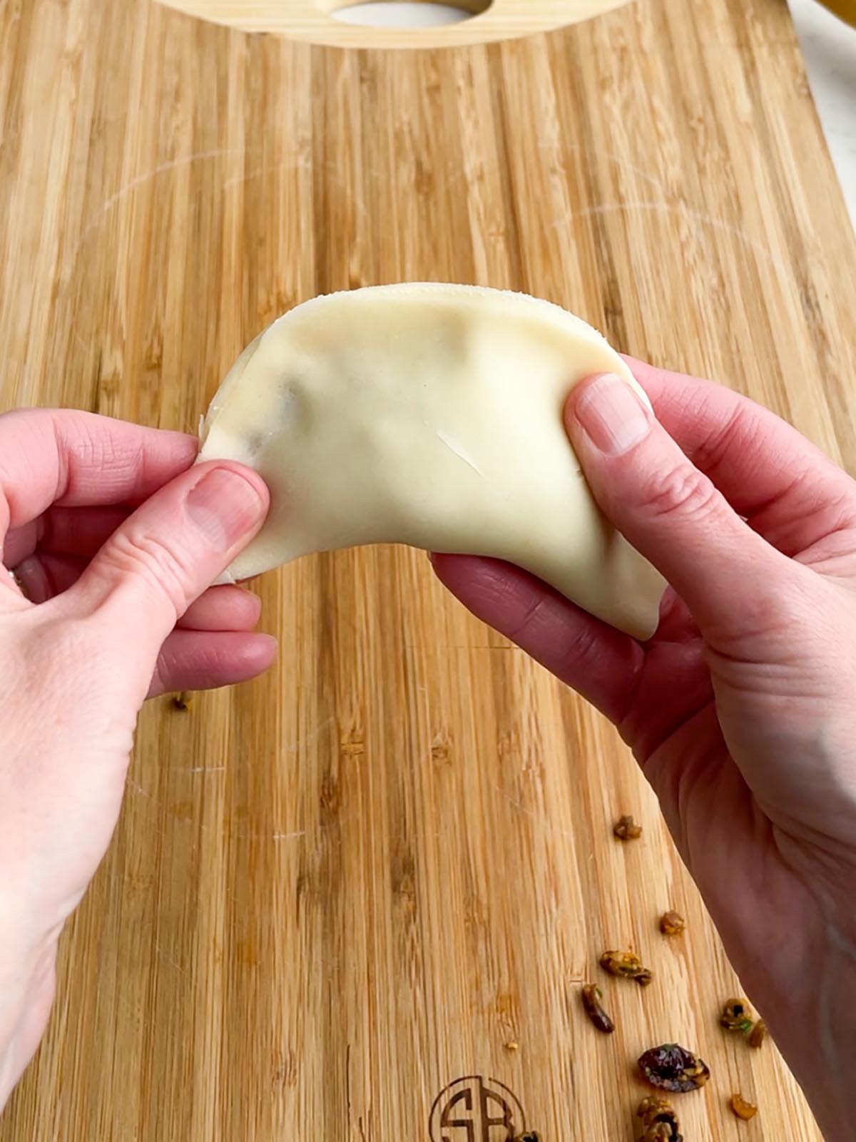two hands pinching together pie dough