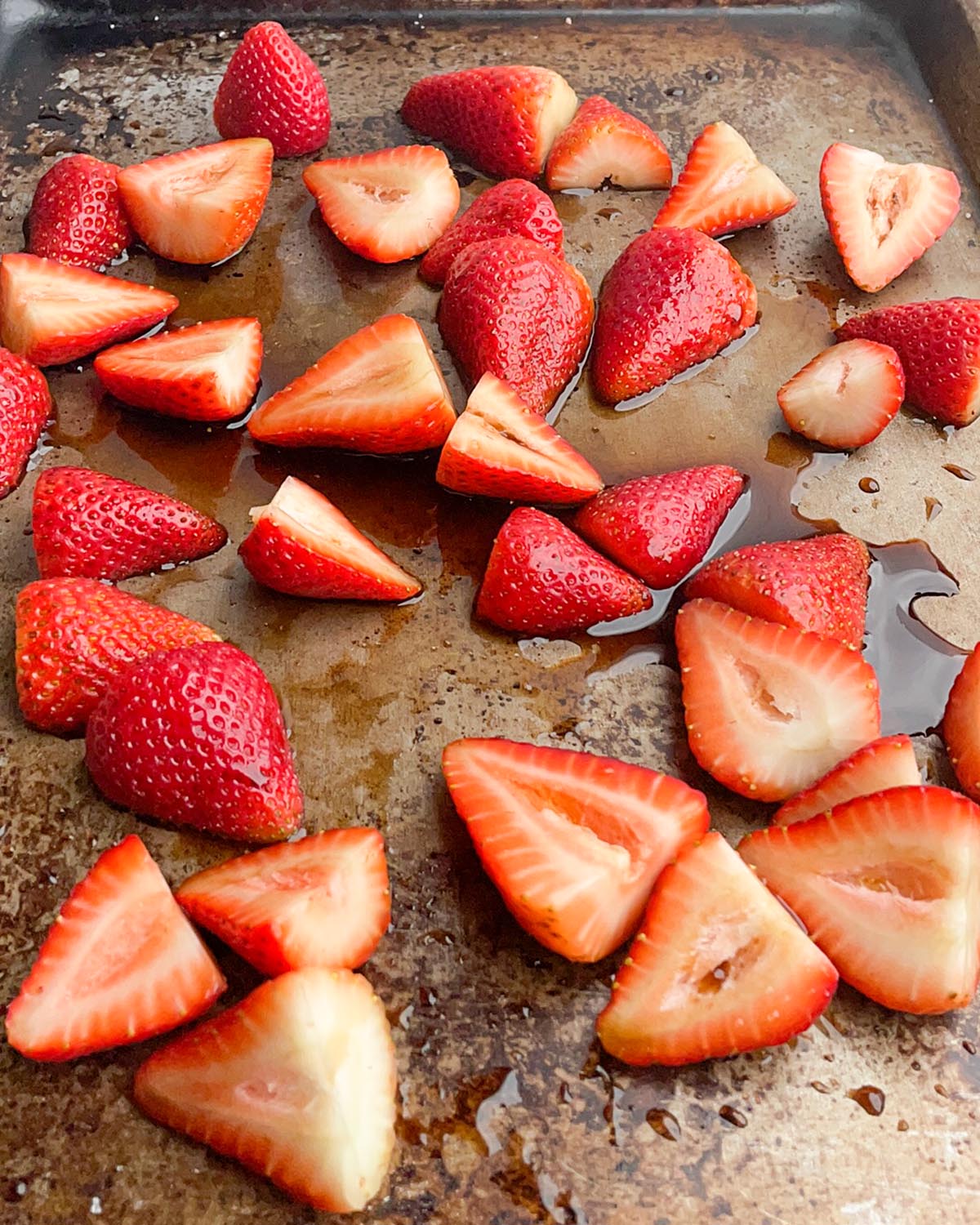 strawberries, balsamic vinegar, maple syrup and salt on a baking sheet
