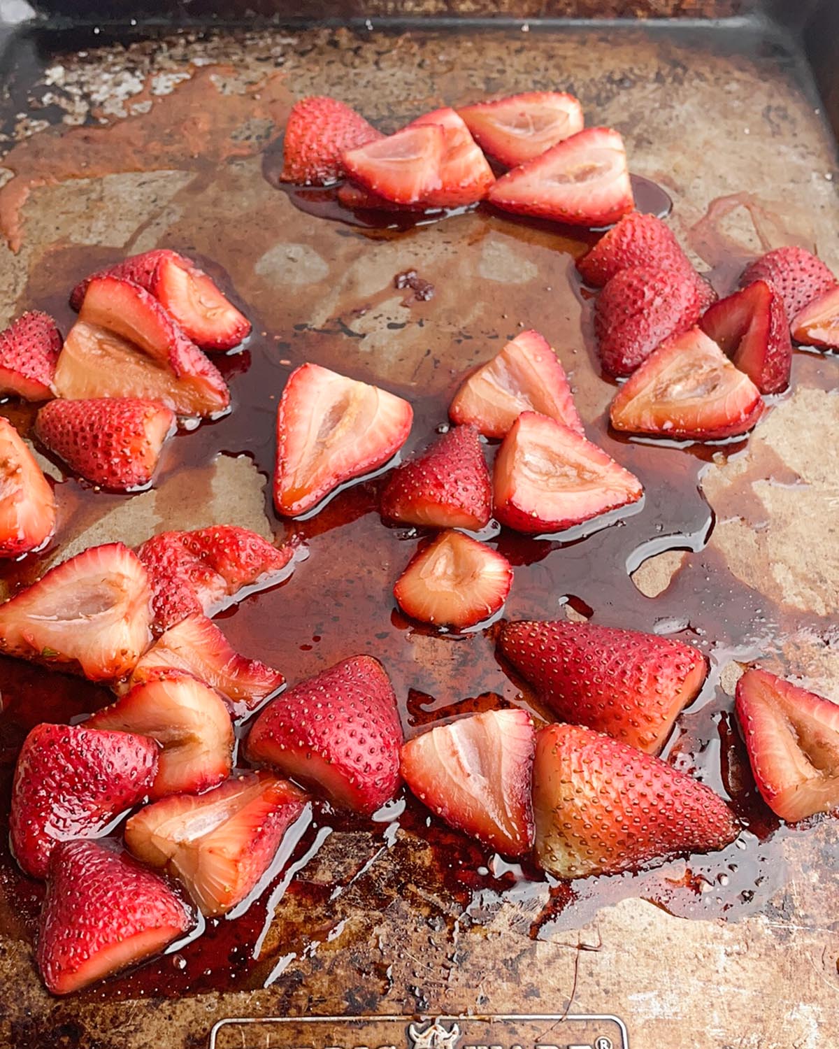 roasted strawberries, balsamic vinegar, maple syrup and salt on a baking sheet