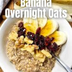 cinnamon banana overnight oats in a white bowl with bananas, cranberries, and walnuts