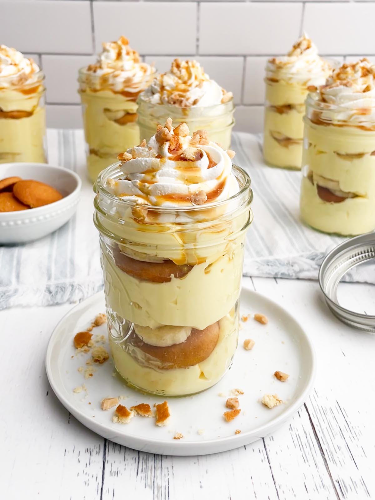 banana pudding cup in a mason jar on a white plate.