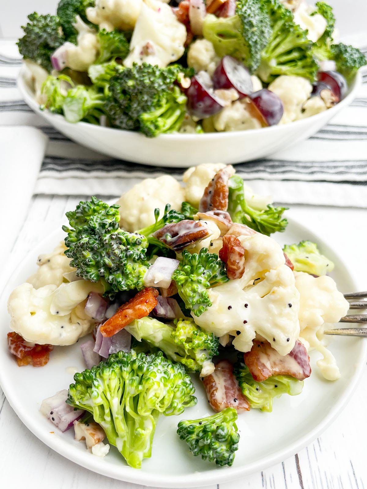 Broccoli cauliflower bacon salad on a white plate