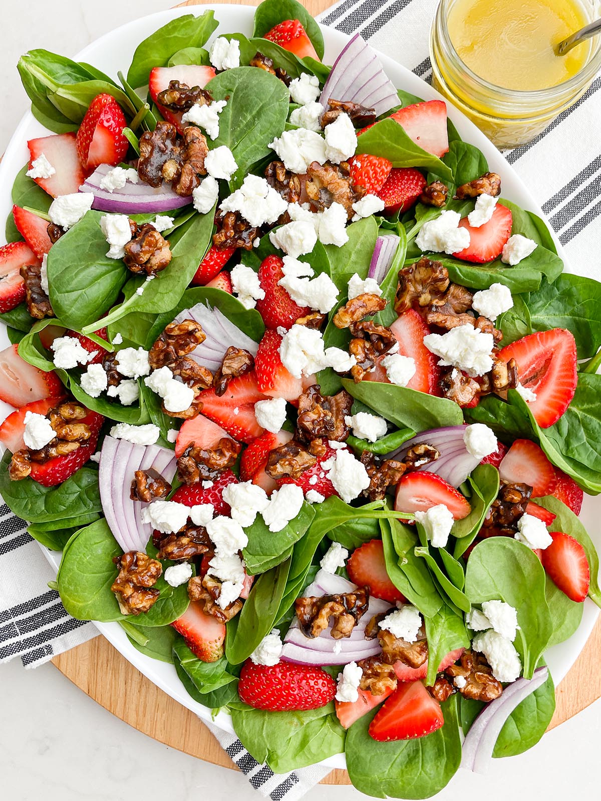 brown sugar candied walnuts on a white countertop on a spinach strawberry salad.