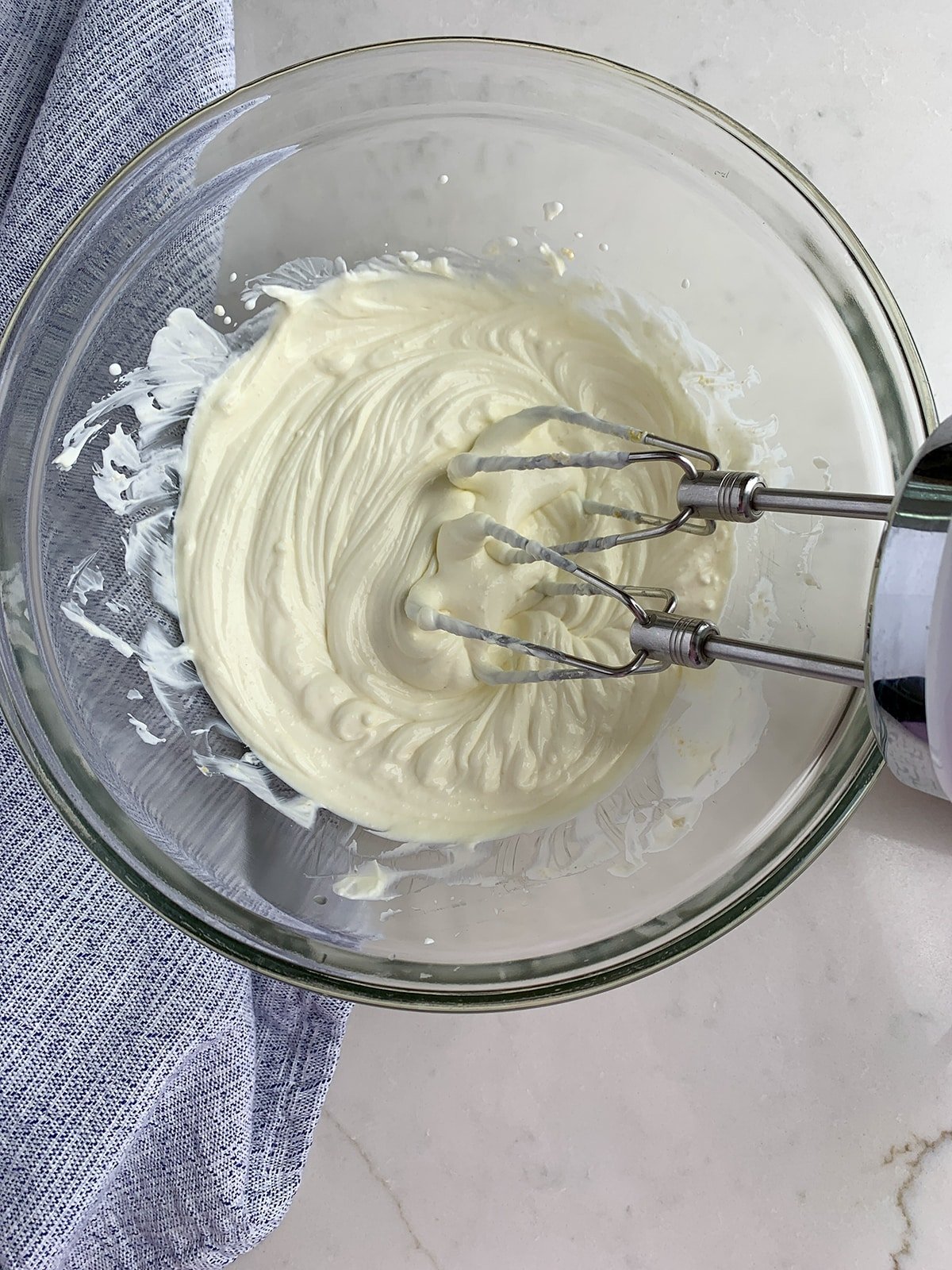 cream cheese and sour cream whipped together in a clear mixing bowl