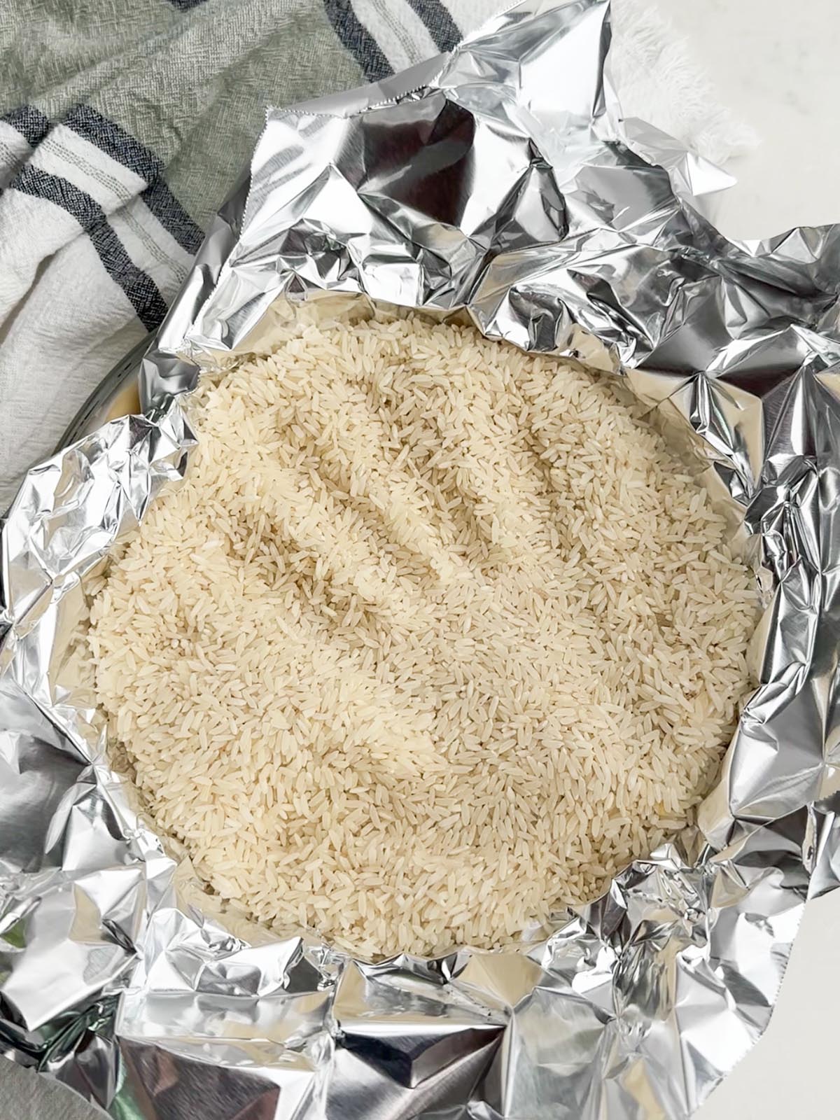 Foil filled with rice in a pie plate.
