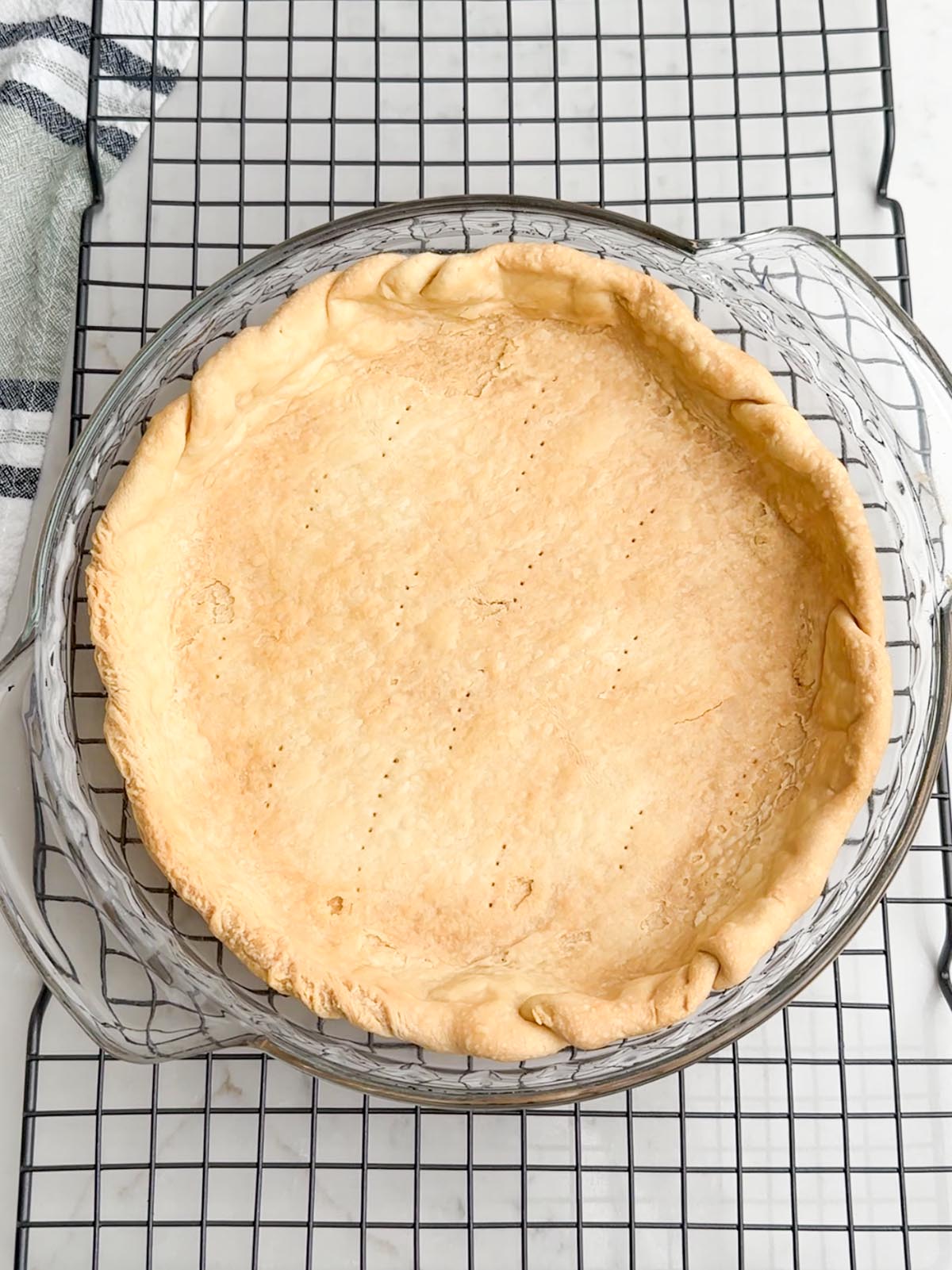 Blind baked pie crust in a clear pie plate.