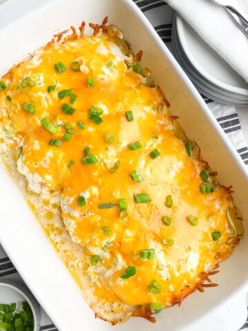 baked chicken with cheese on top in white casserole dish.