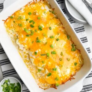 baked chicken with cheese on top in white casserole dish