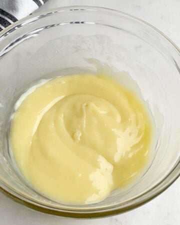 white chocolate, cream, and butter melted together in a clear bowl.