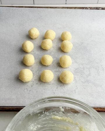 coconut balls on a baking sheet lined with parchment paper. 
