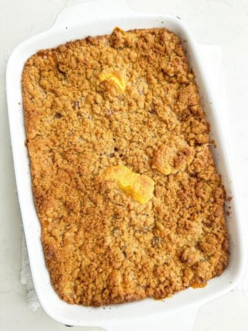 baked apple coffee cake in a white baking dish.