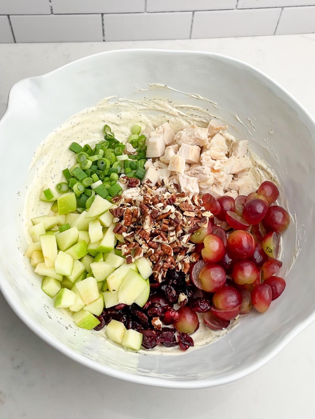 cranberry pecan chicken salad ingredients in a white bowl