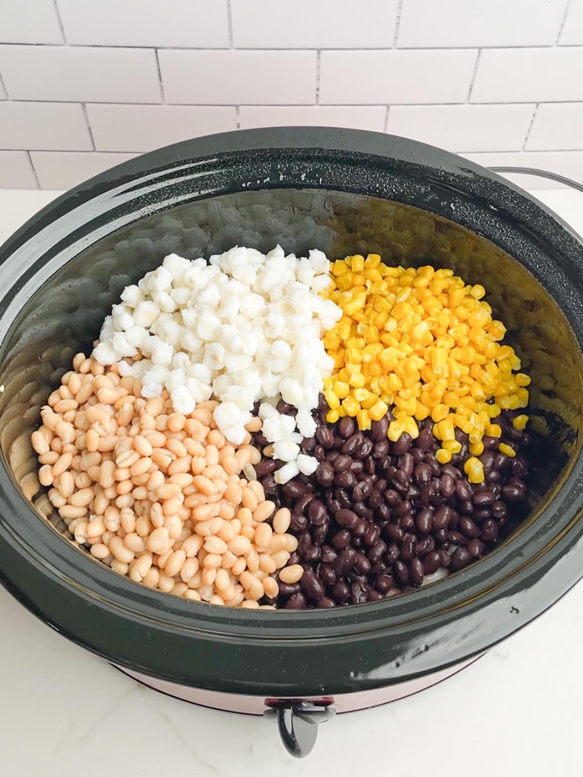 beans, corn, and hominy in black slow cooker