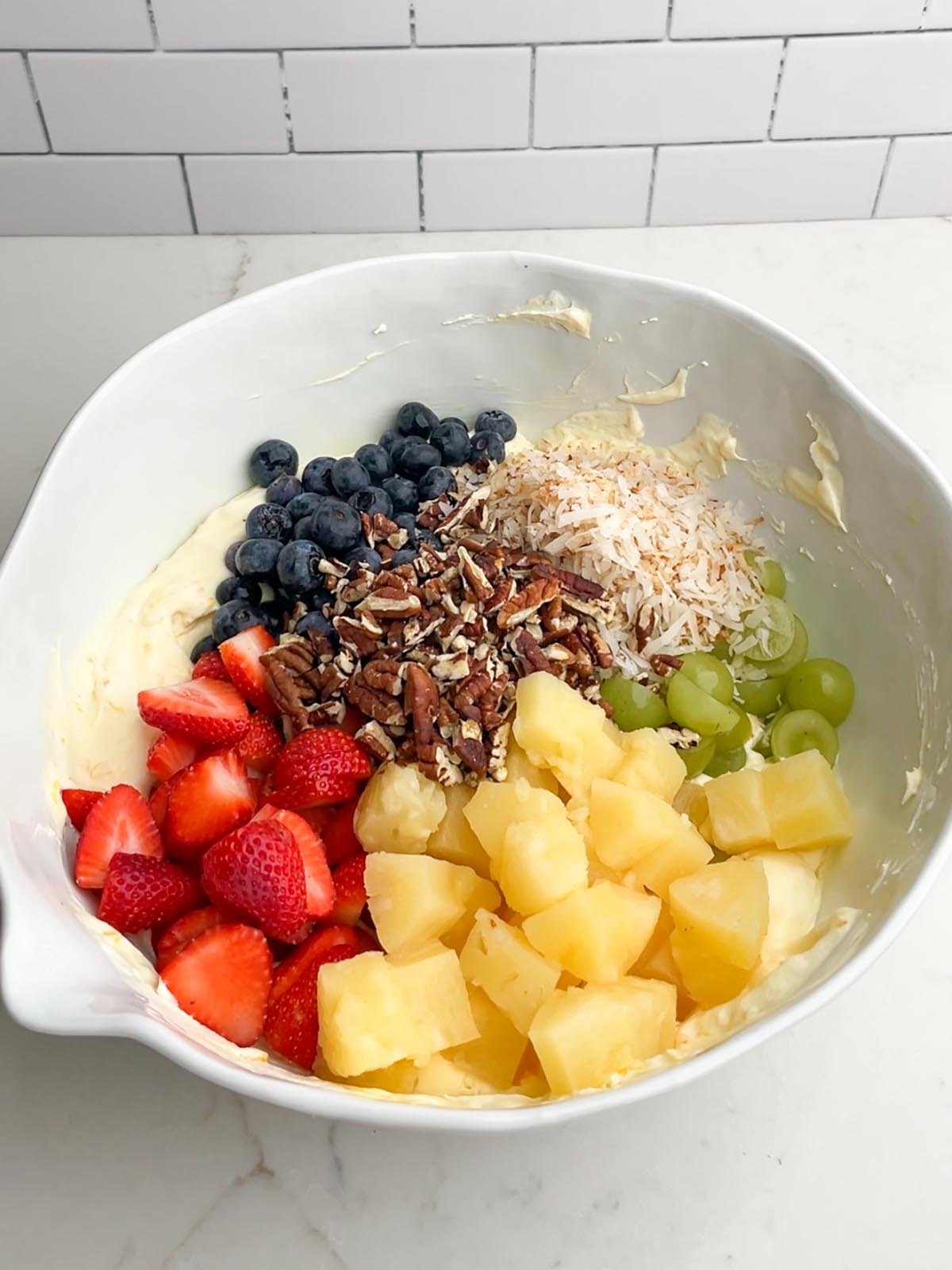 fruit salad recipe with cool whip ingredients in white mixing bowl