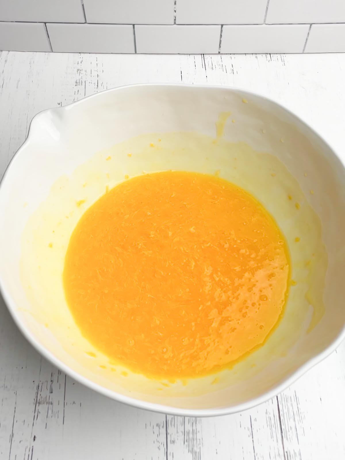 oranges and pudding mix in a white mixing bowl