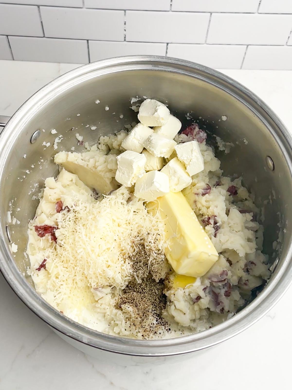 mashed red skin potatoes with butter, cream, cream cheese, Parmesan cheese, and pepper in stock pot