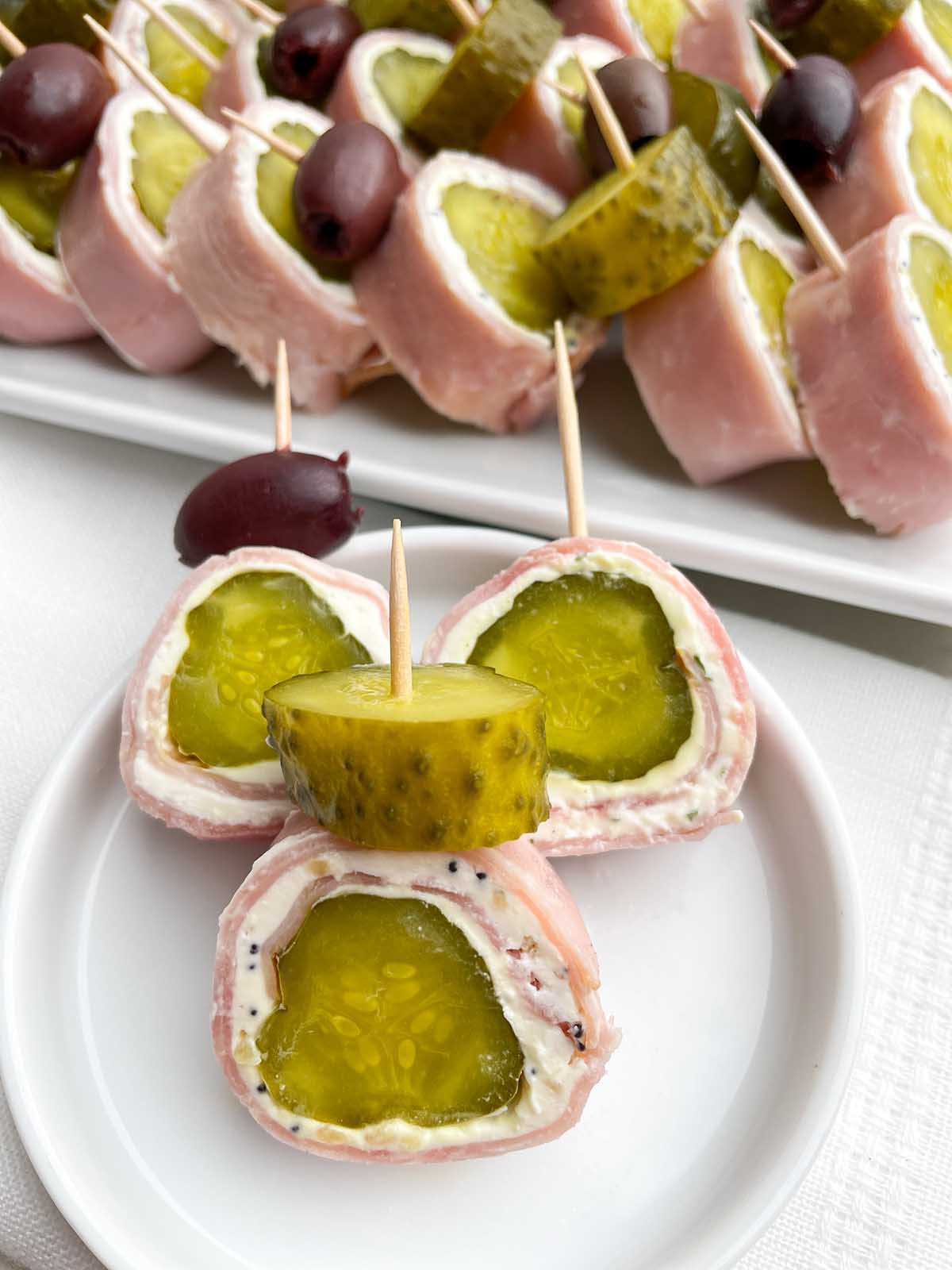 small white plate with three ham and pickle roll ups