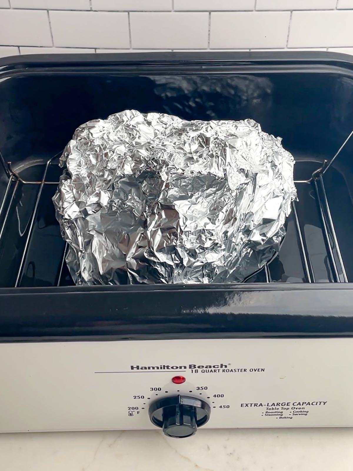 roaster oven ham in foil in roaster oven.