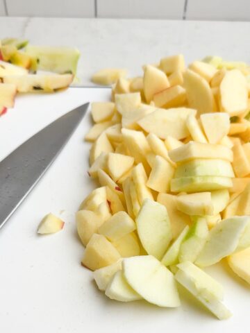 chopped apples on a white cutting board.