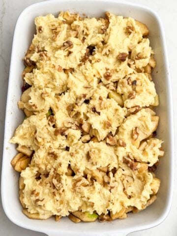 cake batter and walnuts on top of the apple mixture.