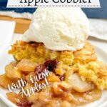 cake mix apple cobbler on a white plate with a scoop of vanilla ice cream on top