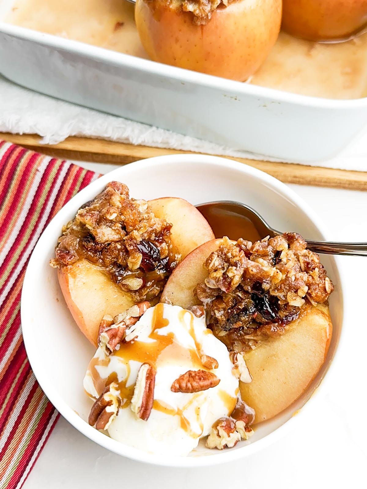 baked cinnamon apple topped with ice cream and caramel sauce
