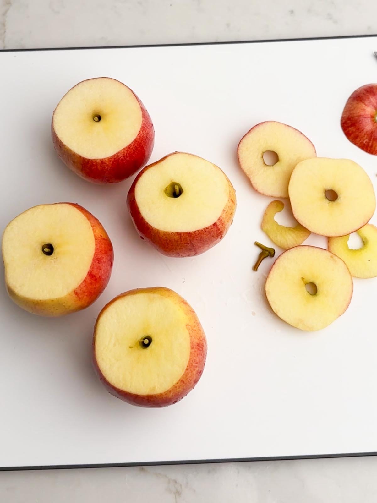 apples with tops cut off on white cutting board