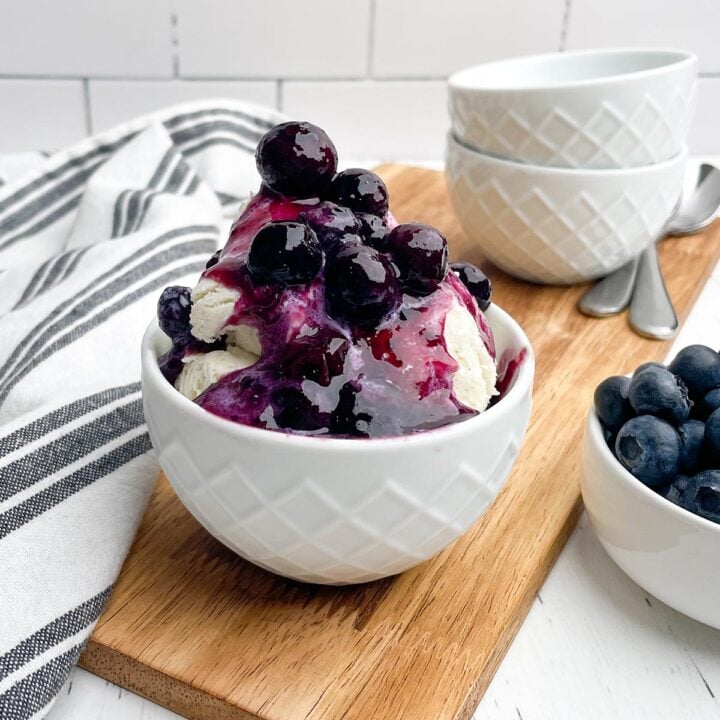 blueberry compote on vanilla ice cream in a white bowl