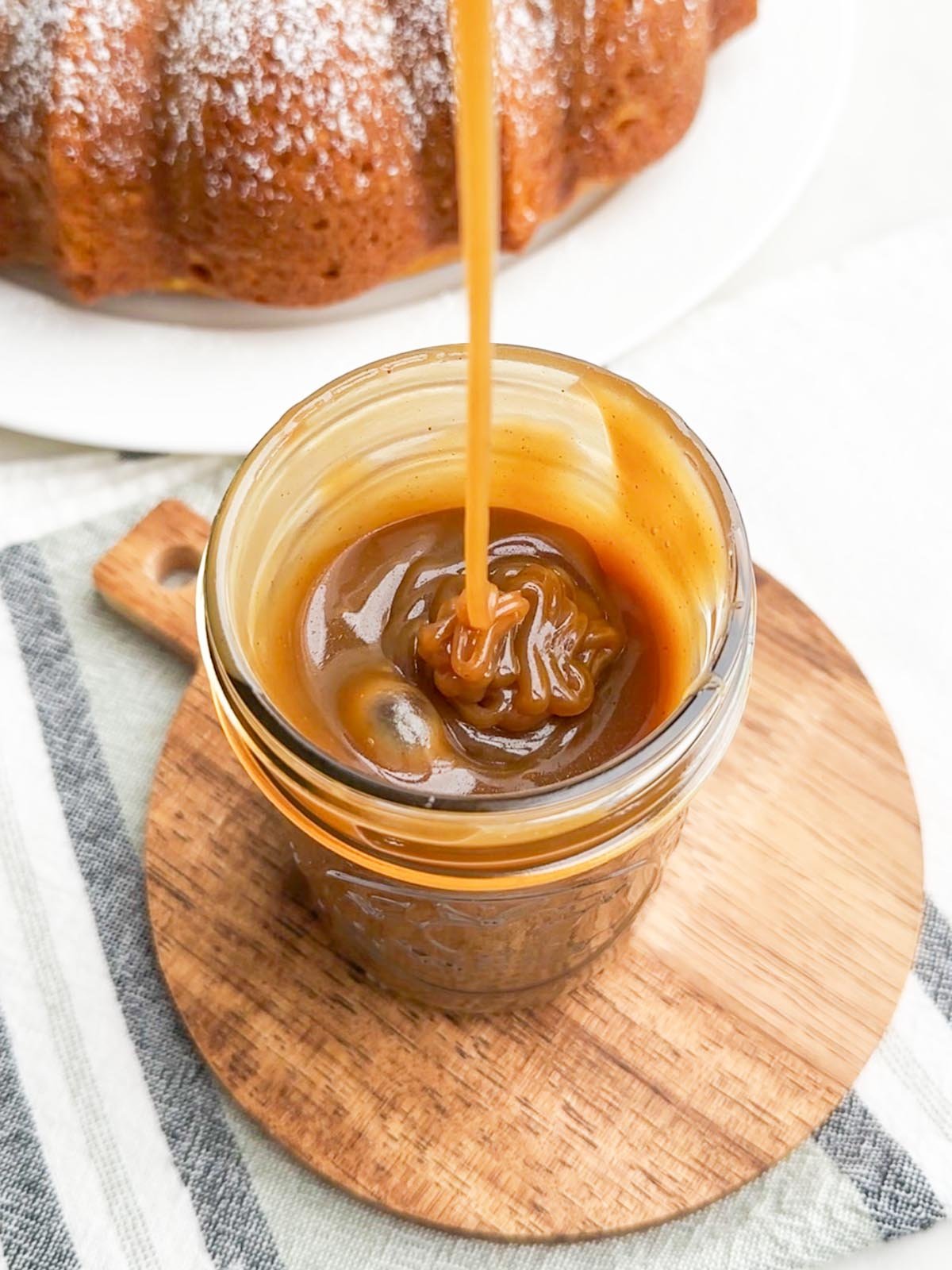 caramel sauce being drizzled into a mason jar.