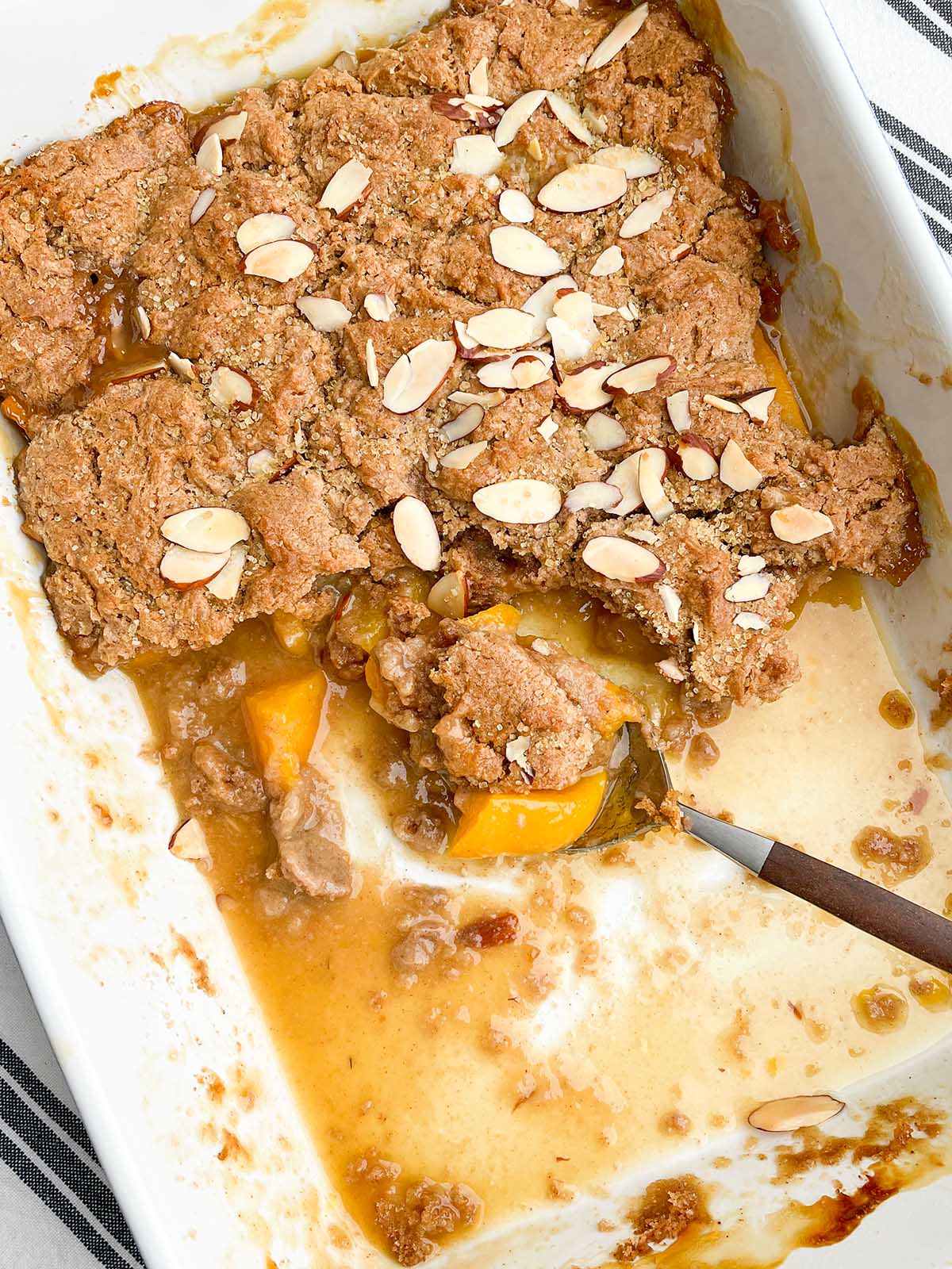 peach cobbler with cake mix in a white baking pan