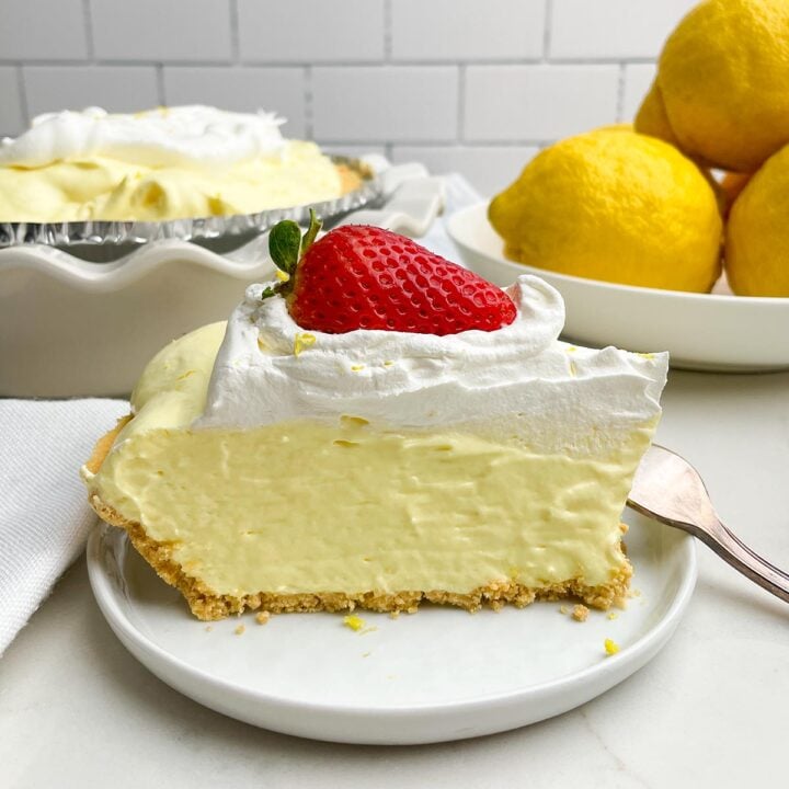piece of Lemon jello pie on a white plate with a fork resting on it