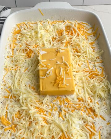 shredded cheese over the Velveeta, pasta, and liquid in a baking pan. 