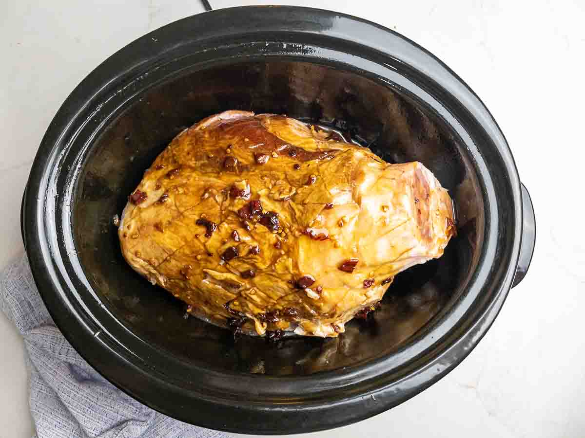 Ham in Crock Pot with maple bourbon glaze poured over it