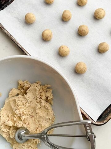 Mexican Christmas cookie dough in a white bowl and rolled into balls.