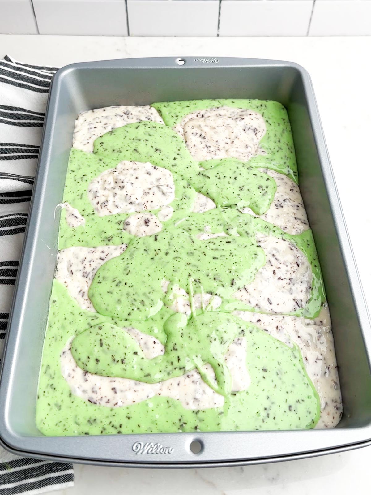 white and green cake batter in a cake pan