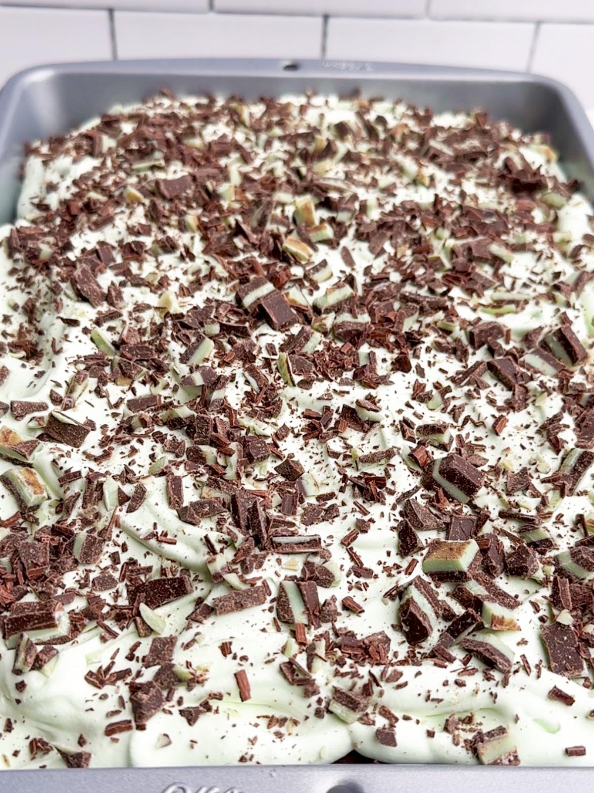 mint chocolate cake with green Cool Whip and Andes mints on top