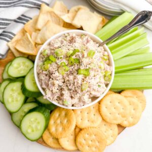 old fashioned ham salad in a white bowl surrounded by cucumbers, celery, and crackers