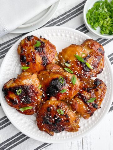 oven baked teriyaki chicken thighs on a white plate.