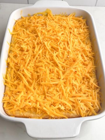 Paula Deen Corn Casserole with shredded cheese on top.