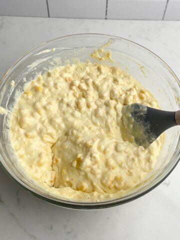 Paula Deen Corn Casserole mixture in clear mixing bowl.