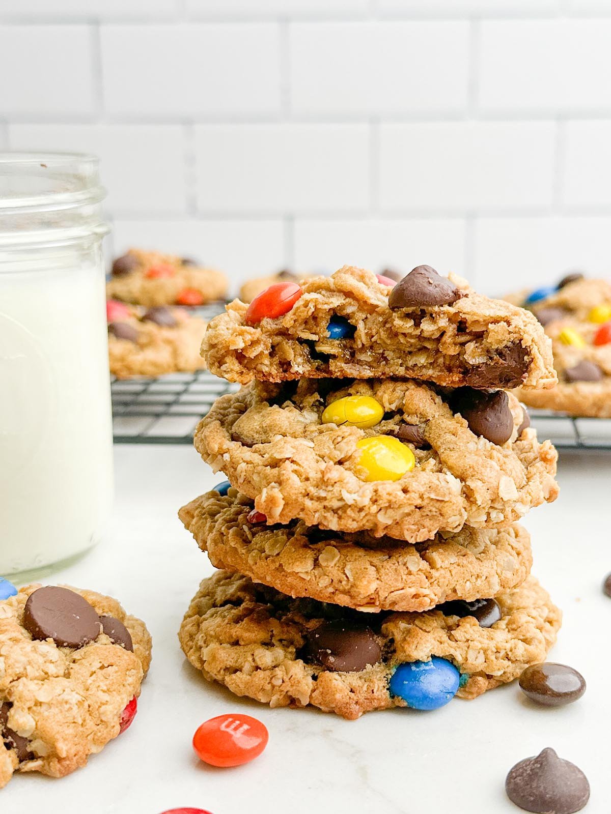 Stack of monster cookies next to a mason jar of milk.