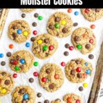 Monster cookies on parchment paper on a baking pan.