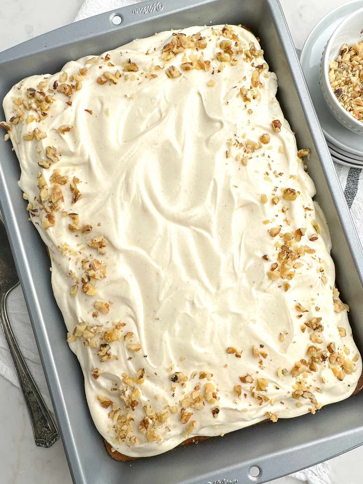pumpkin bars with cream cheese frosting and chopped walnuts on top