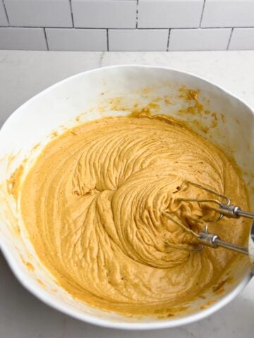 pumpkin cake with yellow cake mix batter in a white mixing bowl.