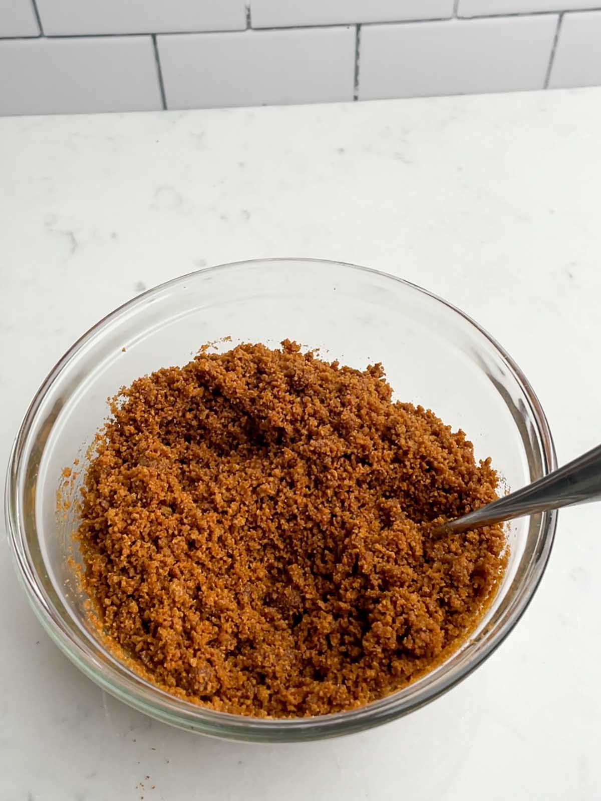 gingersnap crumbs and melted butter in a clear bowl