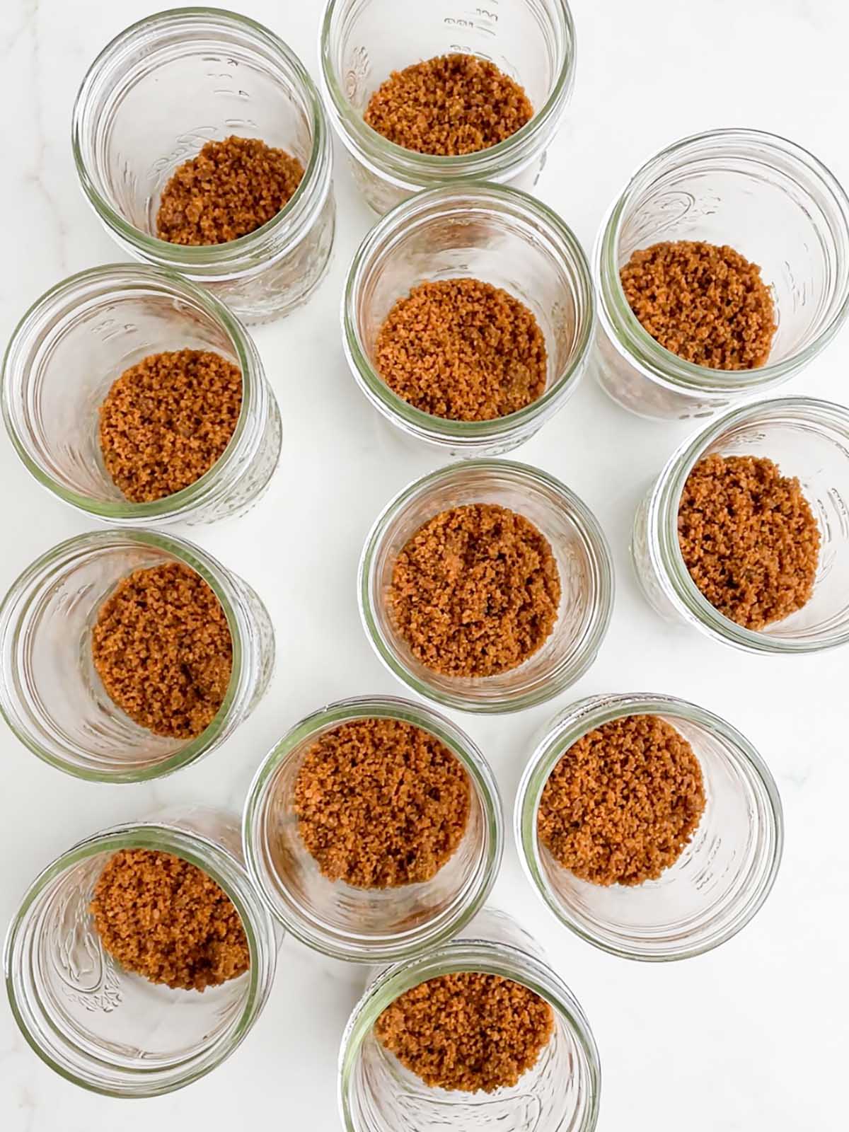 gingersnap crumbs in the bottom of clear mason jars