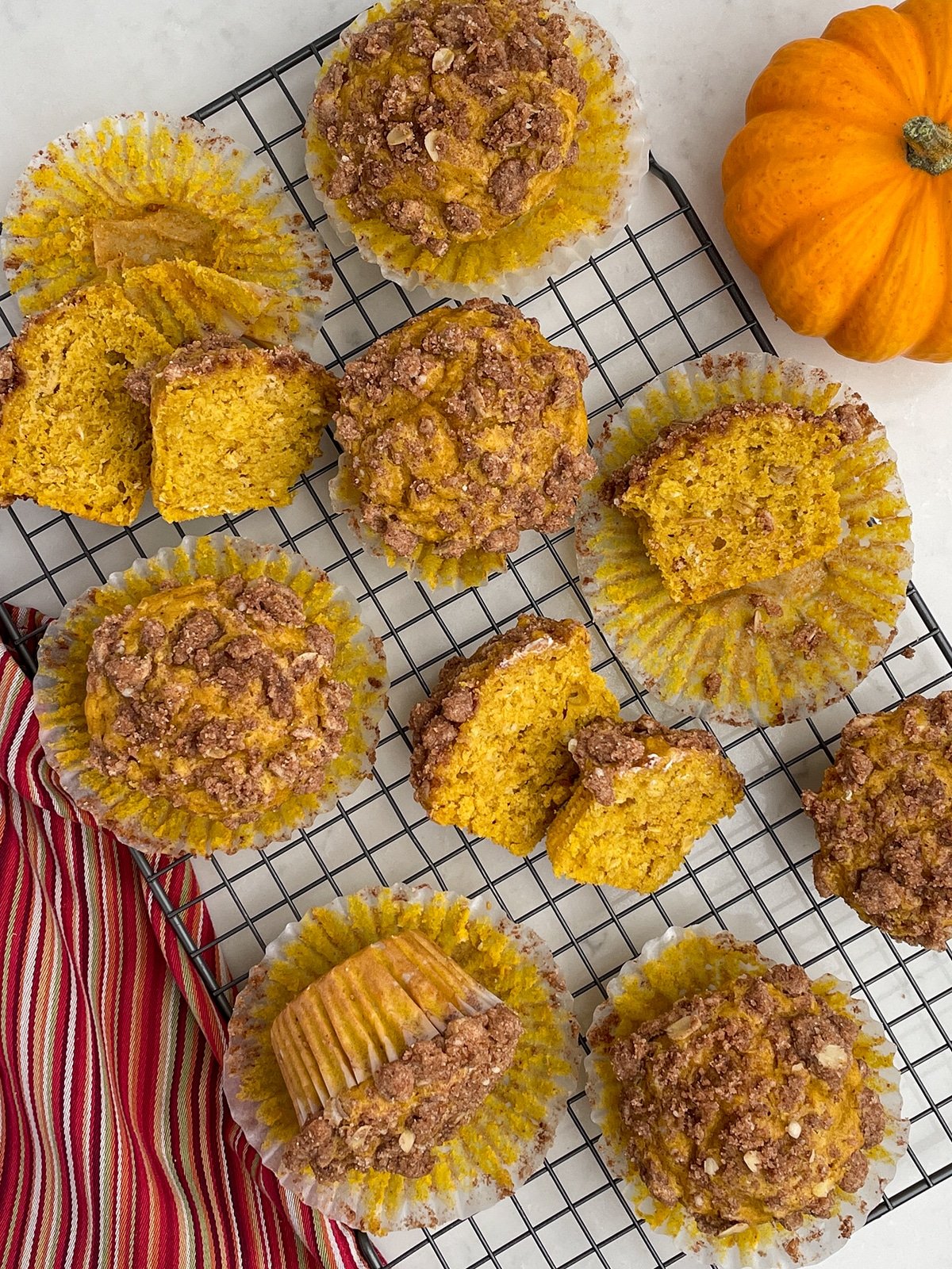 Pumpkin Snickerdoodle Muffins on a baking rack with red striped napkin on the left